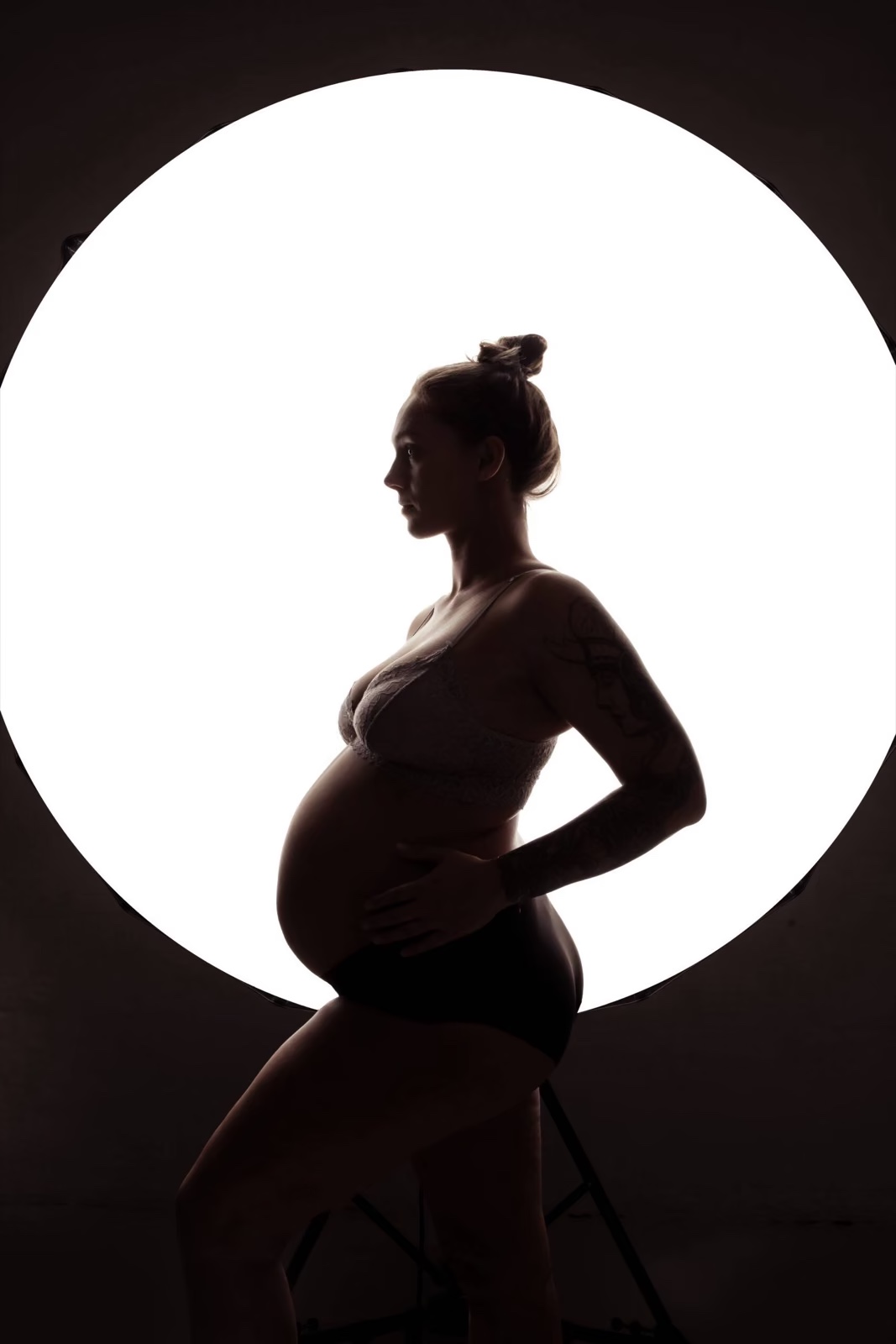 Babybauch-Fotoshooting Hamburg – Silhouette einer schwangeren Frau vor rundem Licht – ästhetisches Schwangerschafts-Fotoshooting bei BEAUTYSHOTS