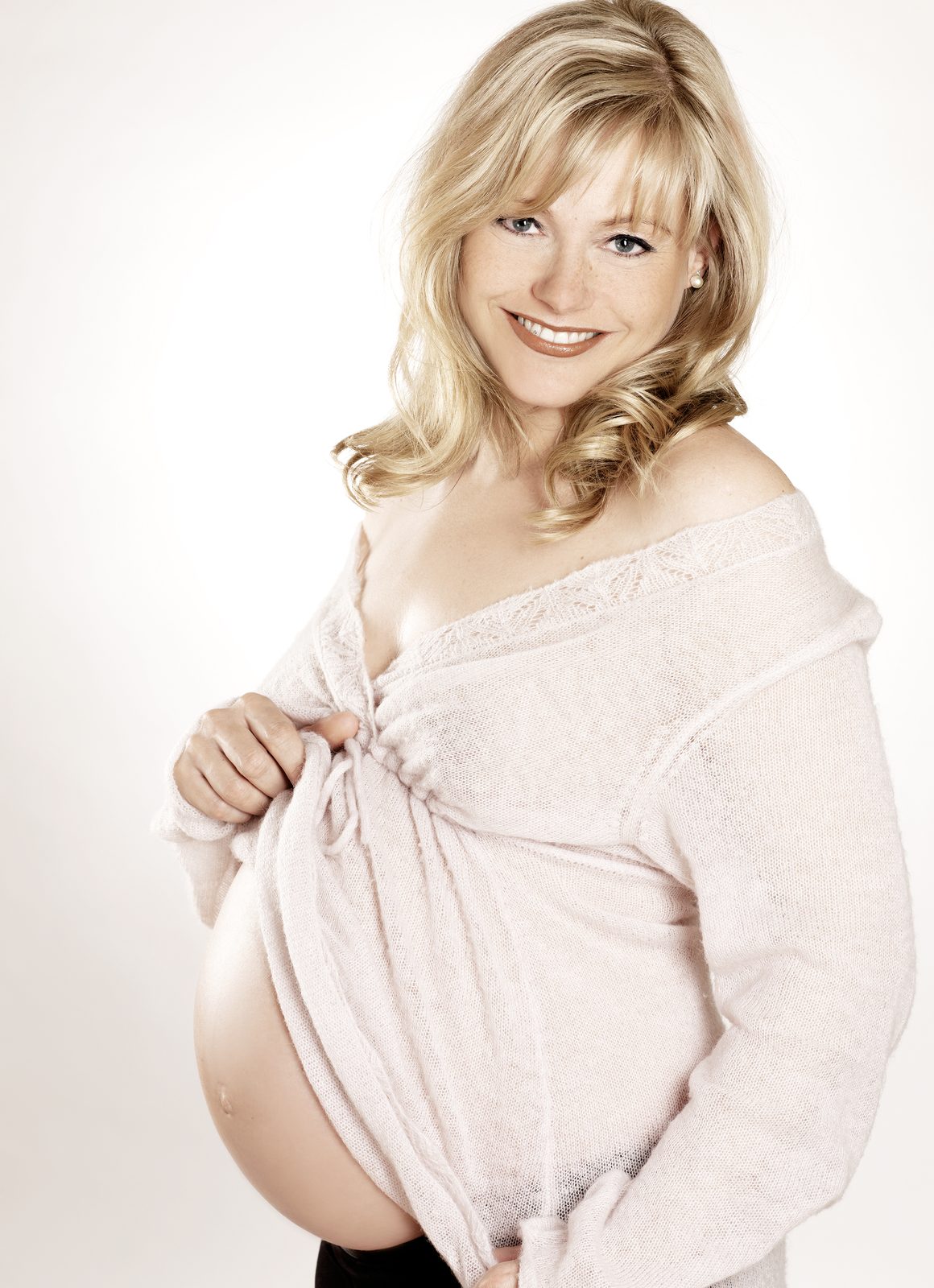 Babybauch-Fotoshooting Hamburg – blonde Schwangere in zartem Rosa – fröhliches Schwangerschaftsshooting