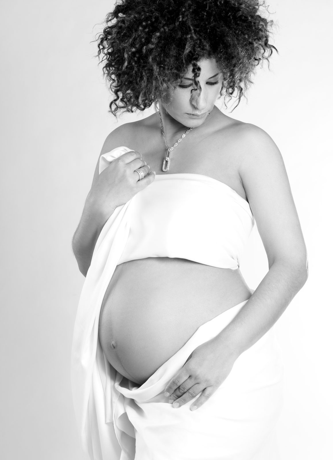 Babybauch-Fotoshooting Hamburg – Hände auf dem Babybauch in Schwarzweiß