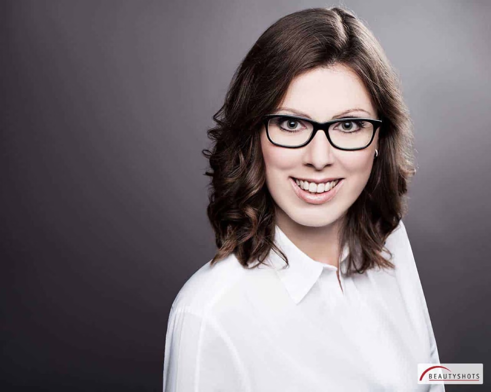 Professionelles Business-Portrait Frau mit Brille und Locken