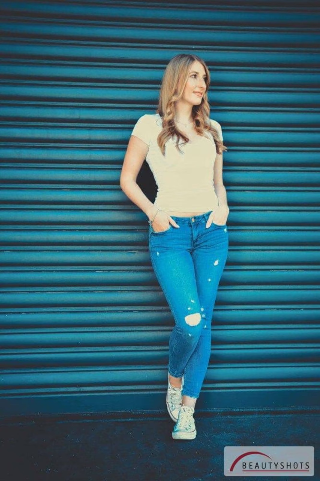 Frau in Jeans vor blauem Rolltor – urbanes Beauty-Fotoshooting in Hamburg
