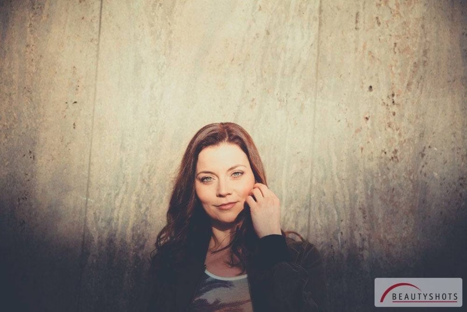 Frau mit langen Haaren vor strukturiertem Hintergrund – stilvolles Pretty Woman Shooting
