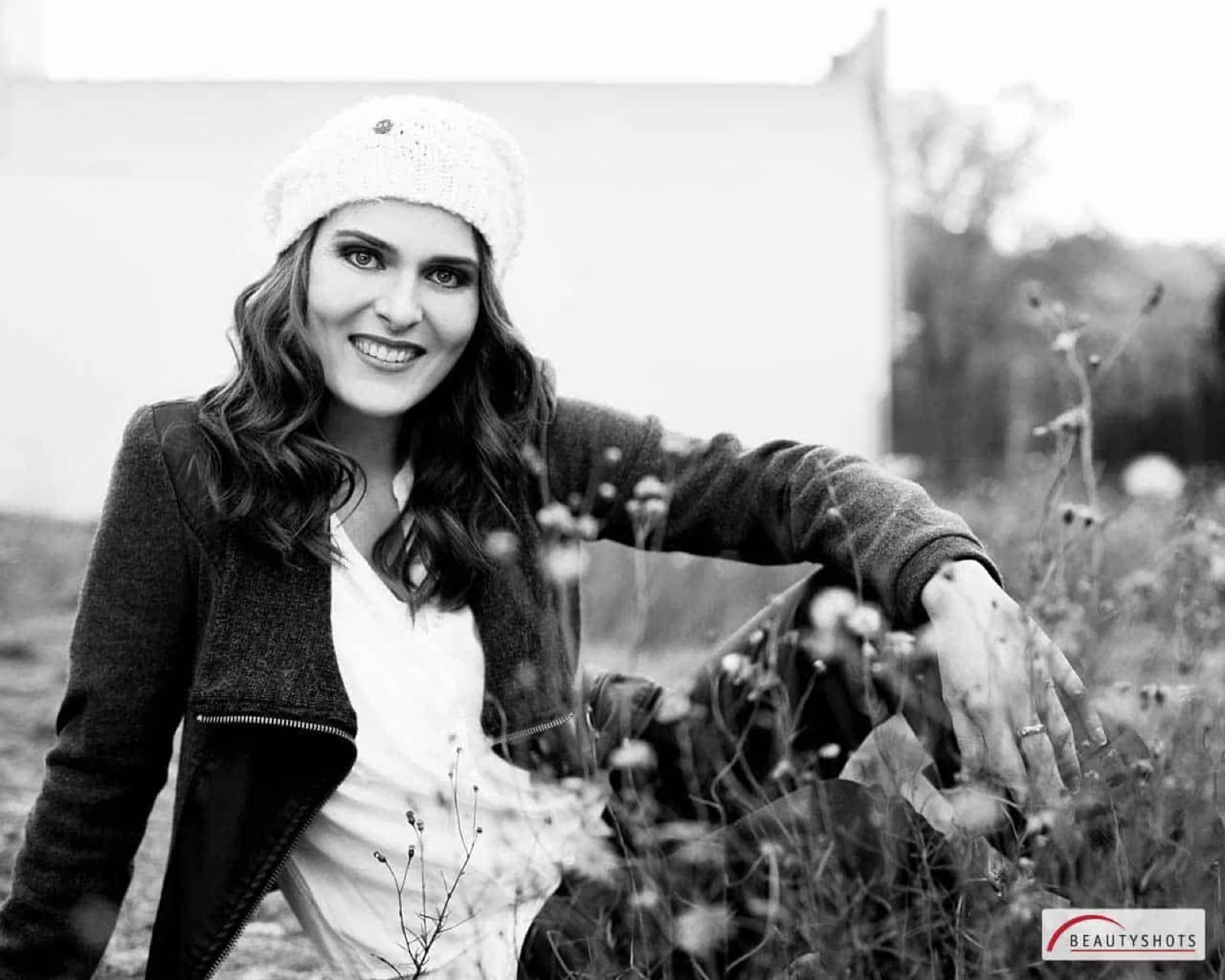 Lächelnde Frau mit Mütze im Schwarzweiß-Look – natürliches Beauty-Fotoshooting im Fotostudio Hamburg