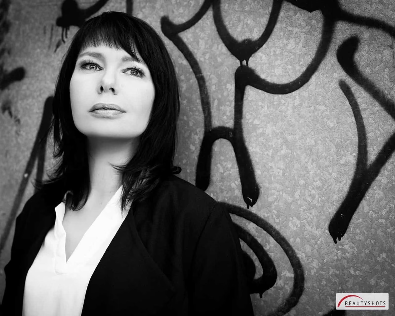 Porträt einer Frau vor grafischem Hintergrund – kreatives Beauty Shooting