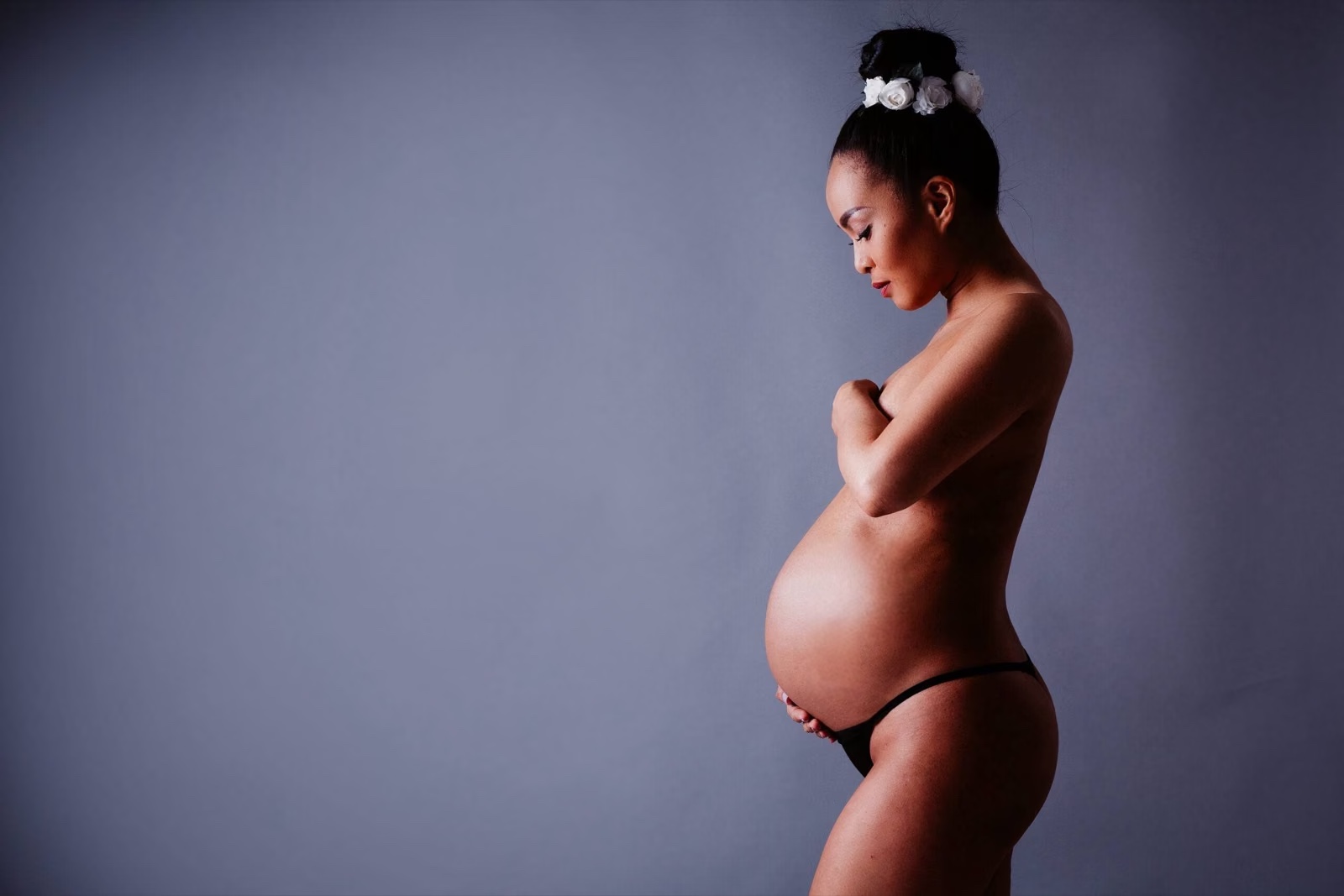 Schwangere Frau im Studio mit sanftem Seitenlicht – sinnliches Babybauch-Shooting in Hamburg
