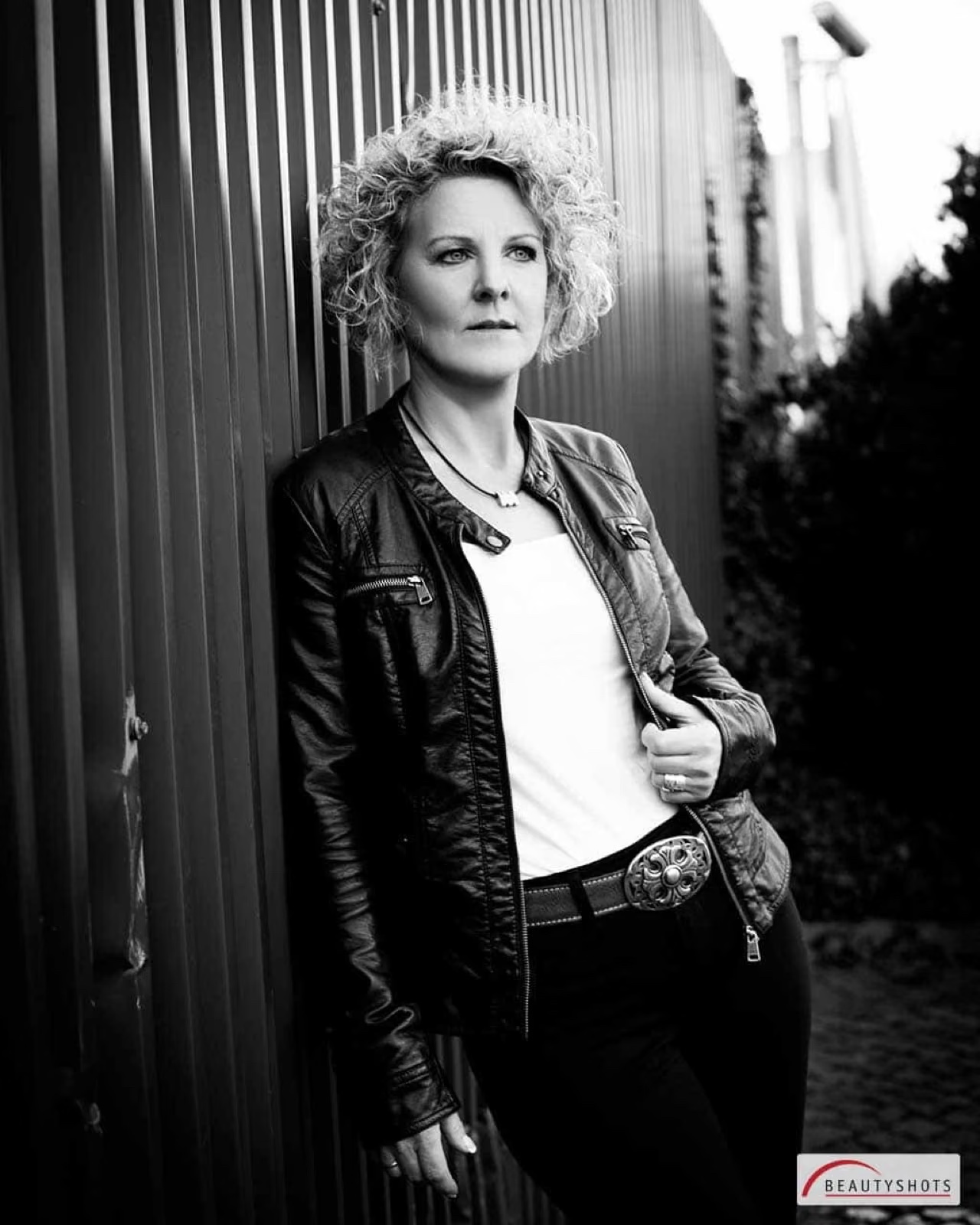 Selbstbewusste Frau in Lederjacke im Freien – ausdrucksstarkes Frauen-Fotoshooting