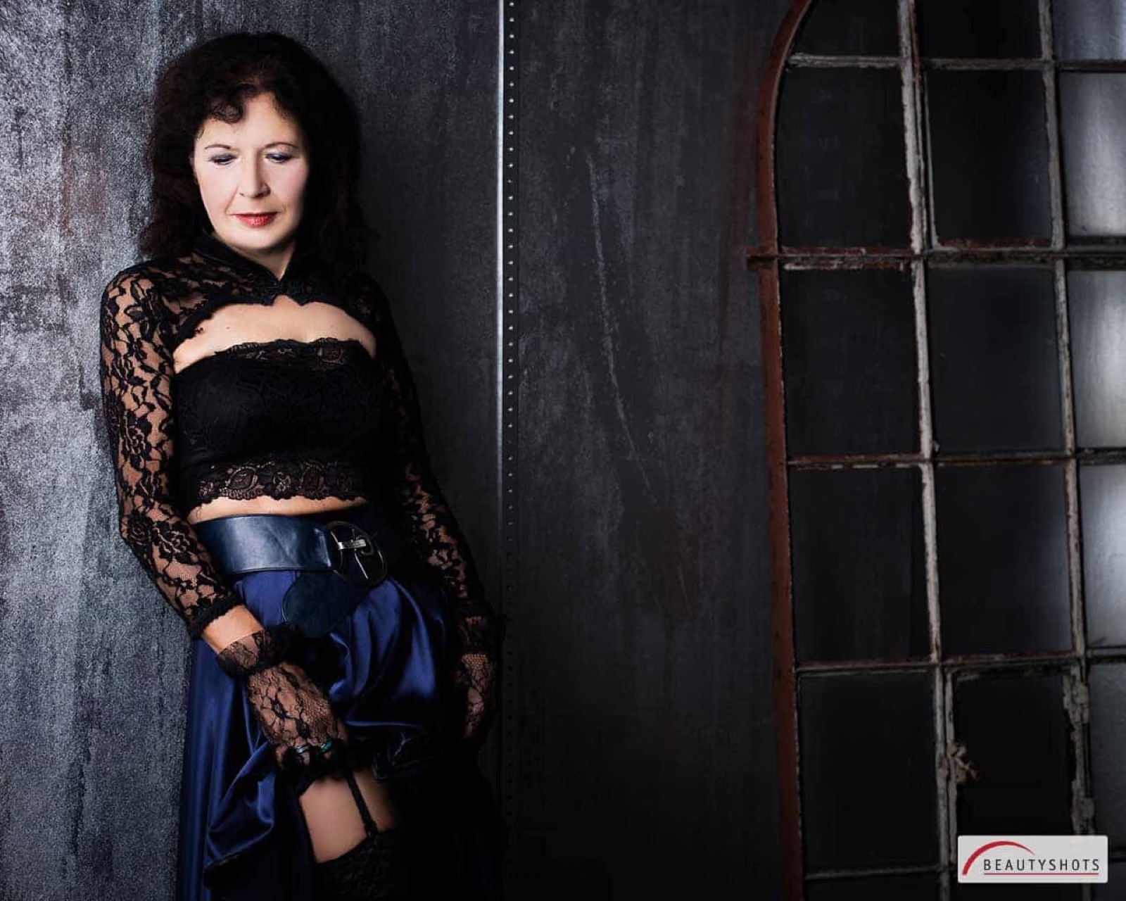 Frau im dunklen Setting mit eleganter Pose – sinnliches Beauty-Fotoshooting bei BEAUTYSHOTS