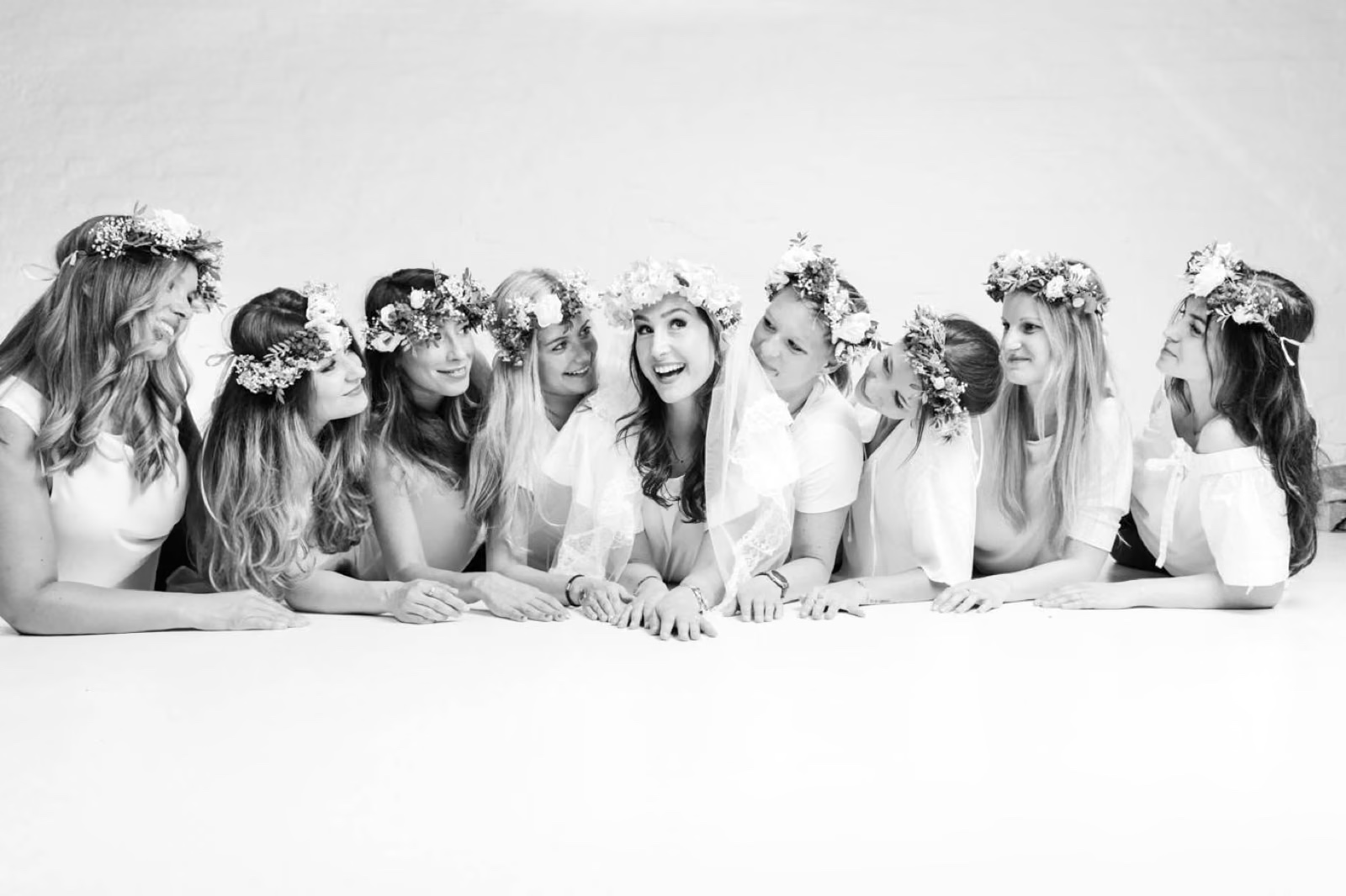 Schwarzweiß-Foto von einer JGA-Gruppe liegend auf dem Boden bei einem Junggesellinnen-Fotoshooting beim Beautyshots Fotostudio in Hamburg
