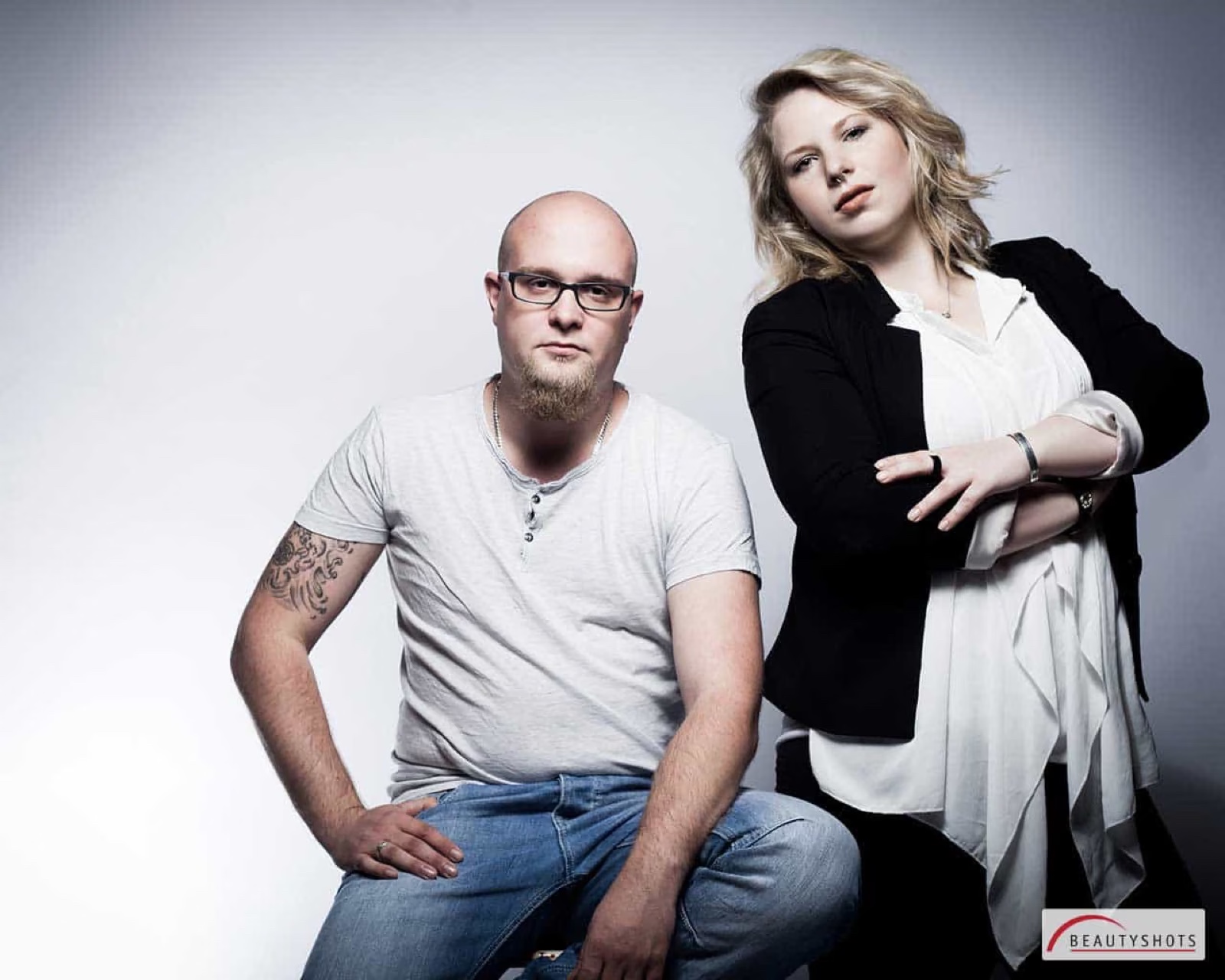 Modernes Paar sitzt nebeneinander im Studio – professionelles Fotoshooting für Paare