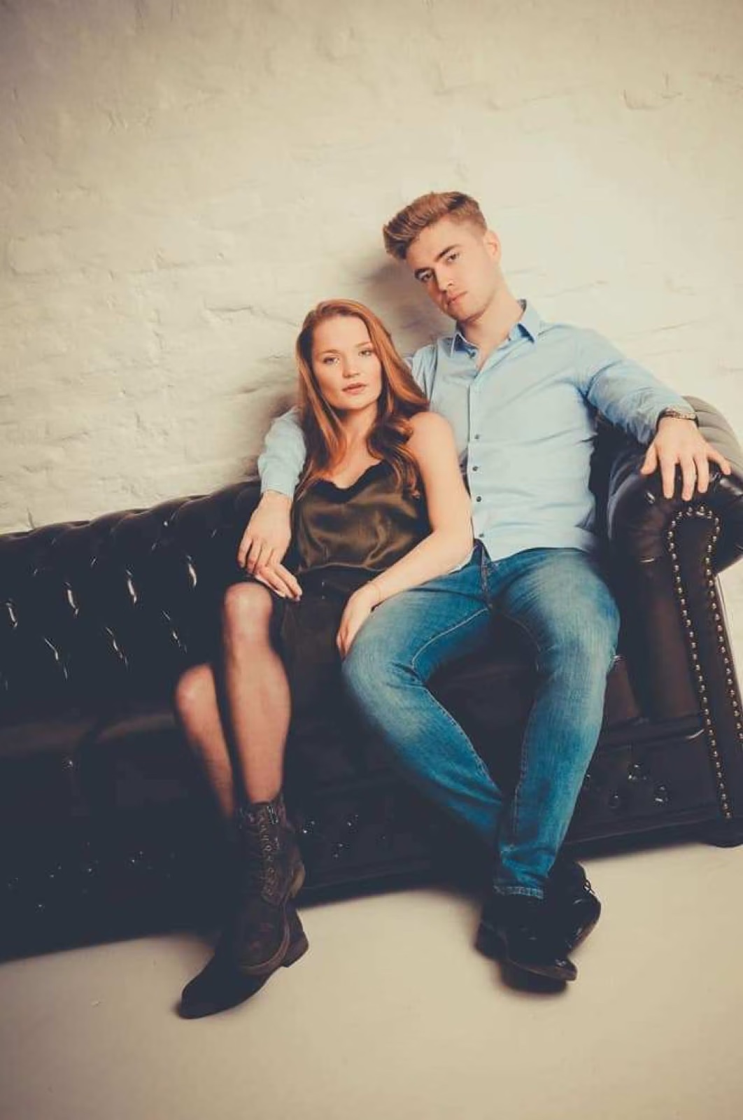 Junges Paar sitzt gemeinsam auf einem Sofa – Paar-Fotoshooting im Studio