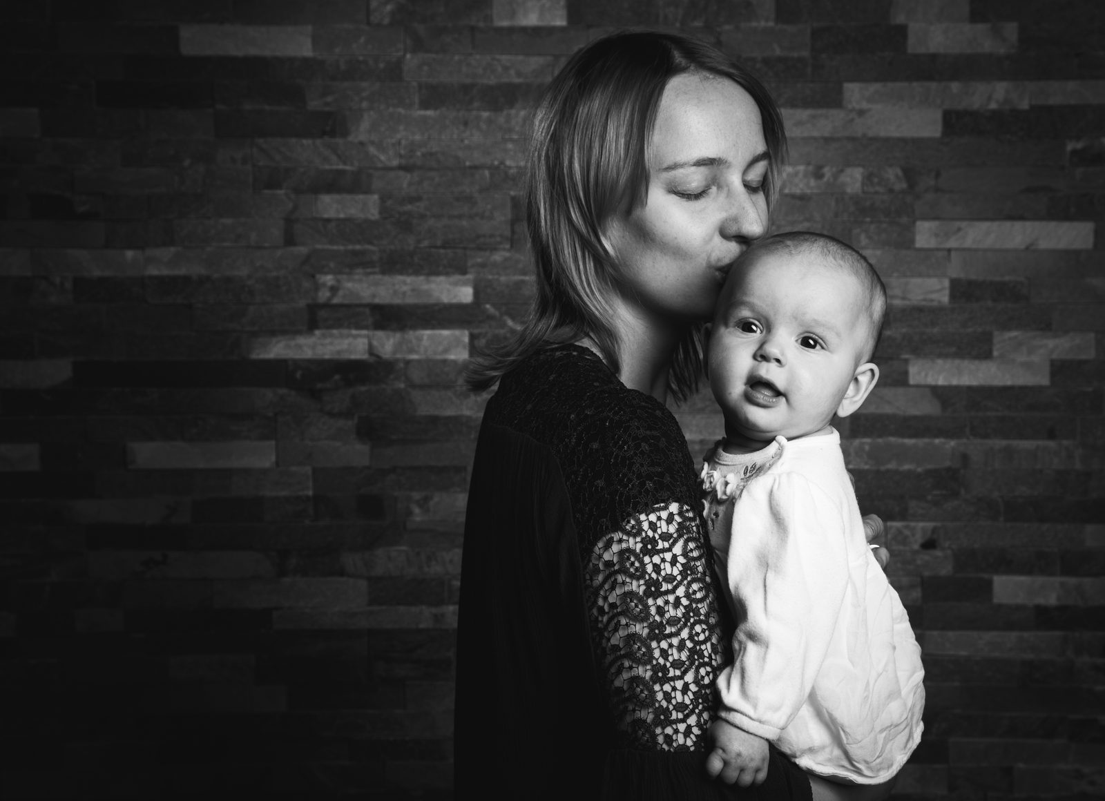 Mother kissing baby's head—black and white portrait in a Hamburg photo studio