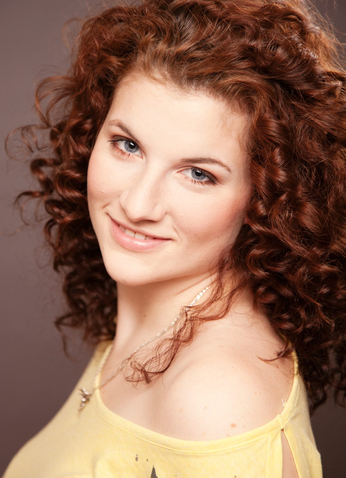 Smiling woman with curly red hair — studio portrait in Hamburg