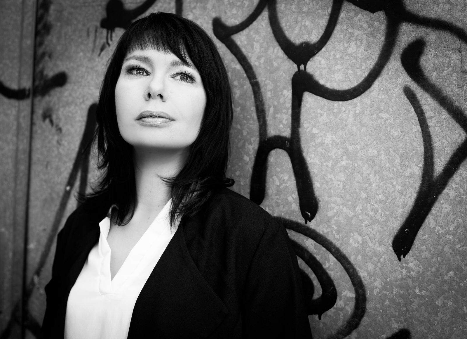 Schwarz-weiß-Porträt einer Frau vor Graffiti-Wand – Fotoshooting in Hamburg
