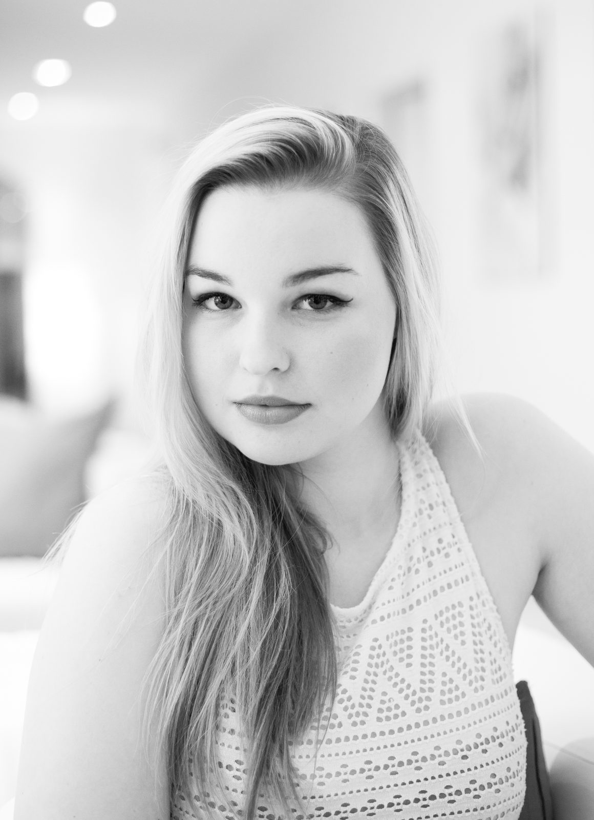 Black-and-white portrait of a young woman with long hair indoors