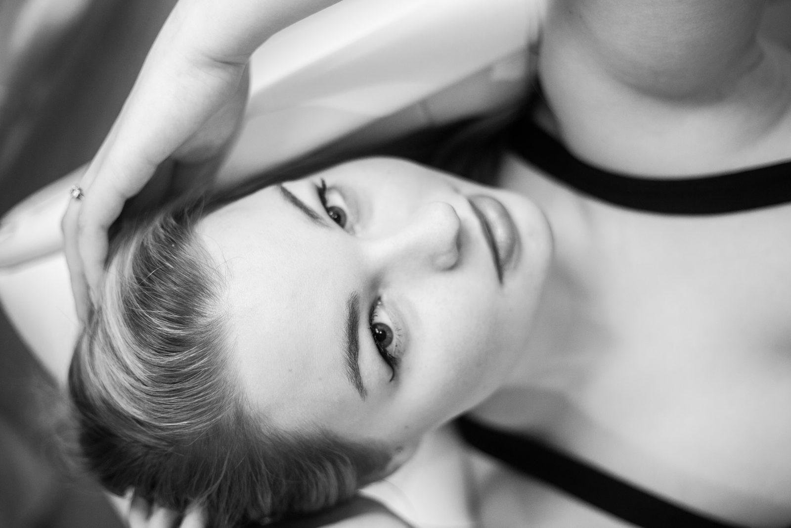 Black-and-white portrait of a woman with head tilted back, gazing into the camera