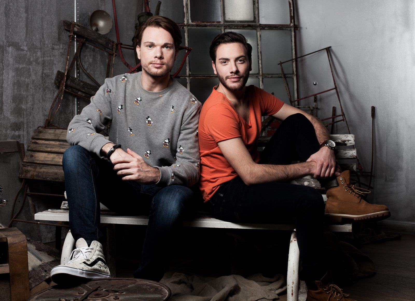 Two men sit casually on a bench—portrait session with vintage industrial props