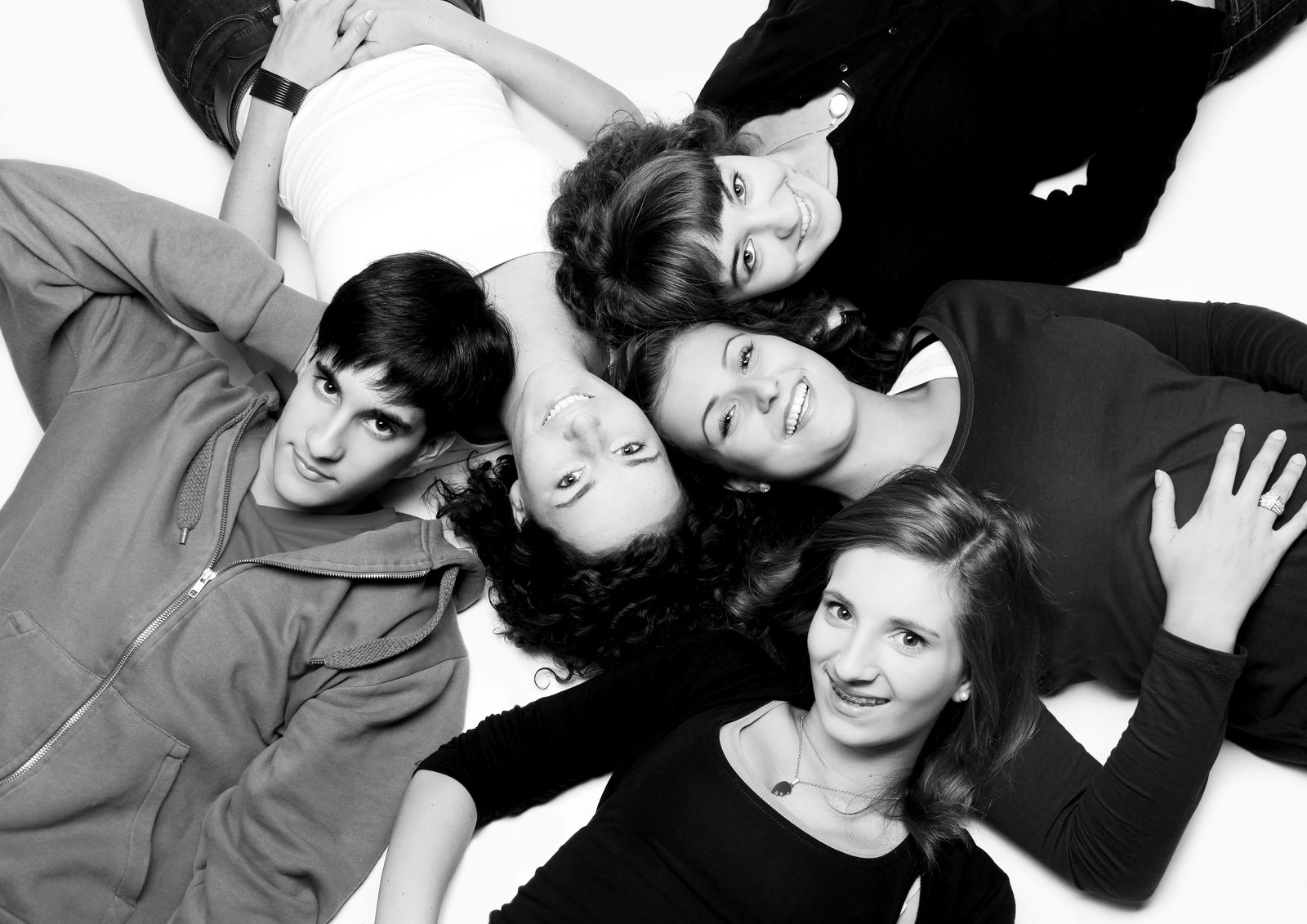 Fünf Freunde liegen lächelnd im Kreis – Schwarz-Weiß-Fotoshooting in Hamburg