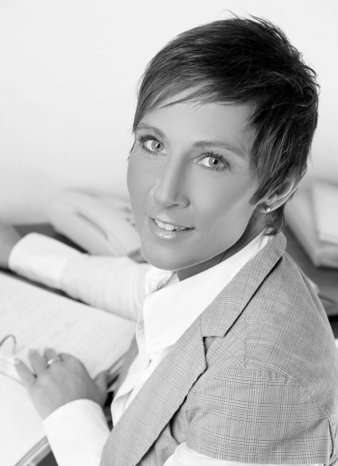 Frau im Blazer lächelt beim Fotoshooting in Hamburg in die Kamera