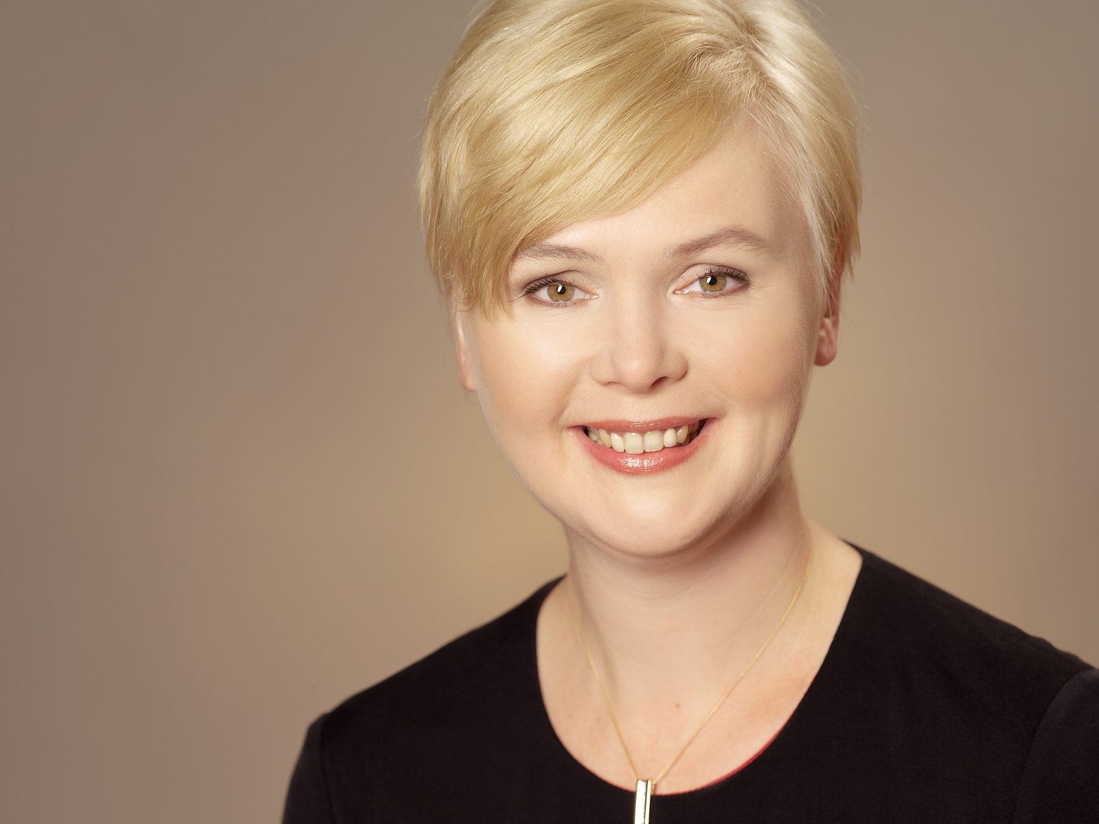 Businessporträt einer lächelnden Frau mit kurzem blondem Haar im Fotostudio in Hamburg