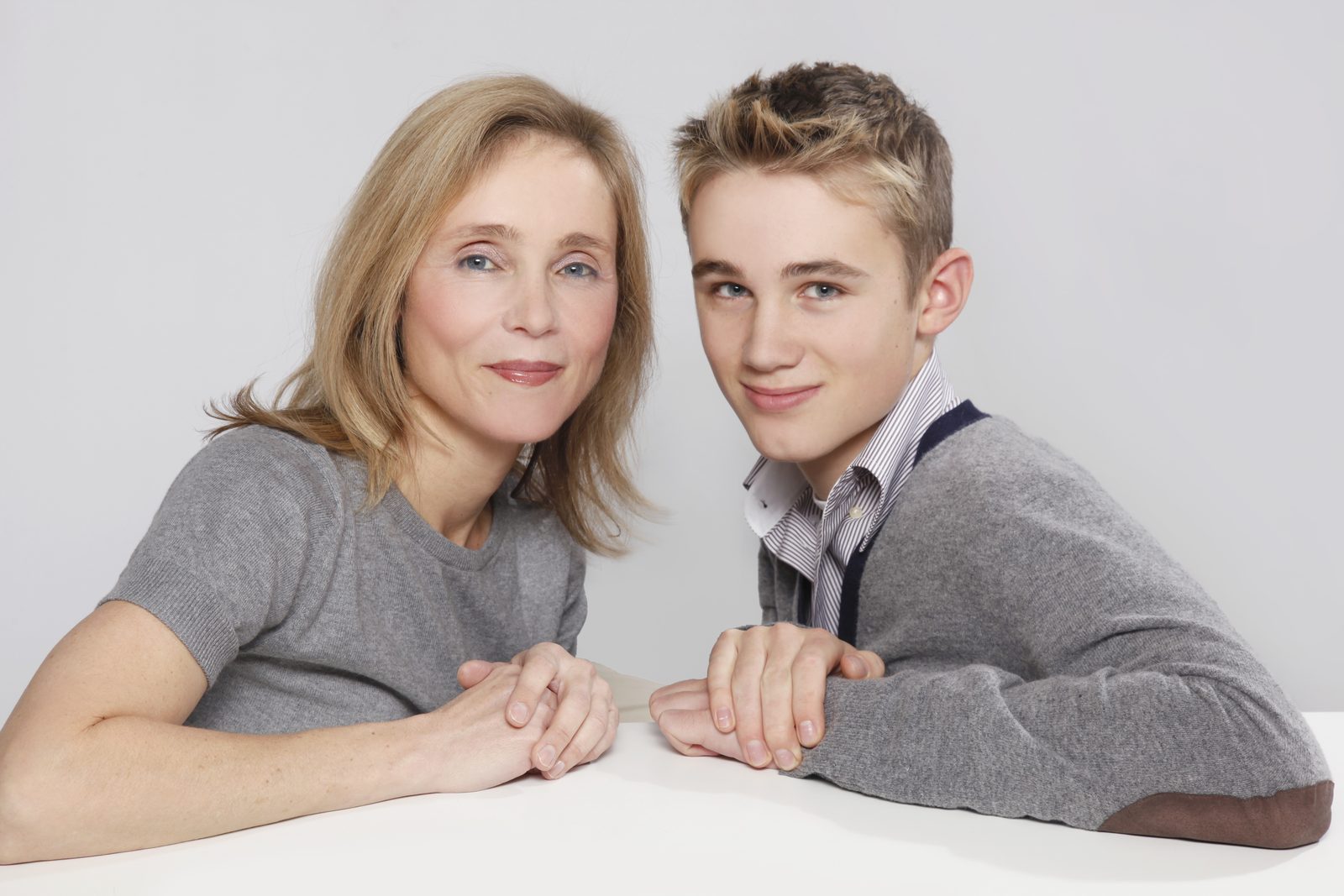 Mutter und Sohn lächeln gemeinsam im Fotostudio in Hamburg