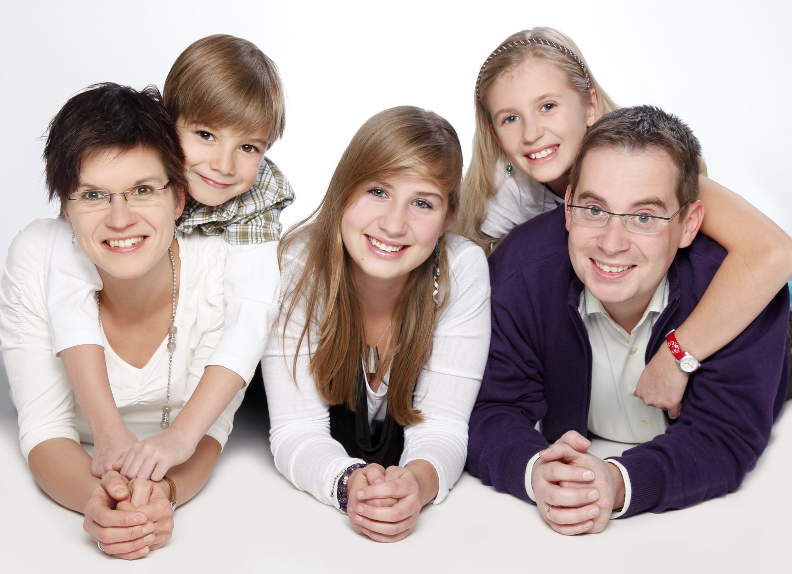 Familie mit drei Kindern lächelt gemeinsam bei einem Fotoshooting in Hamburg