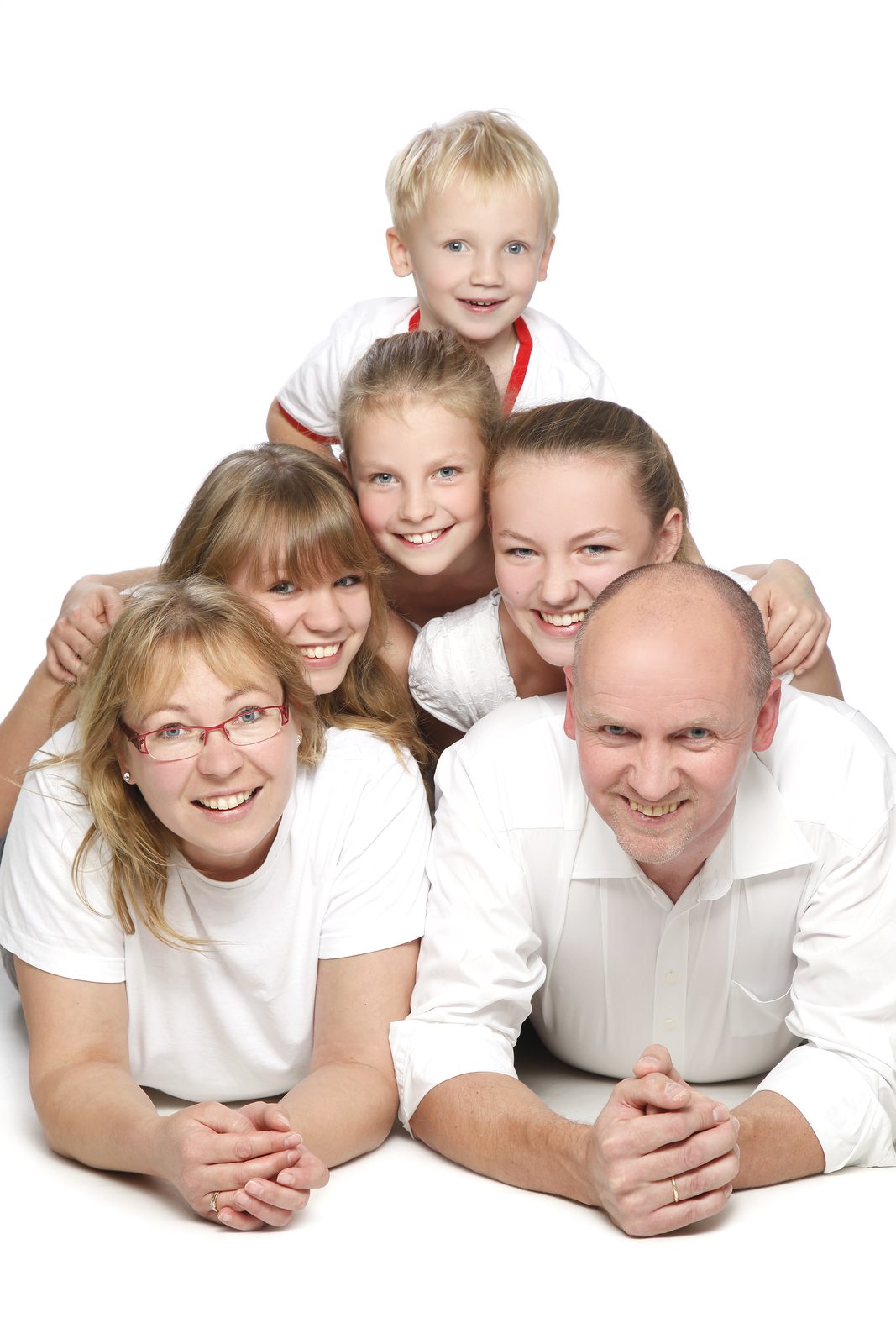 Familie mit vier Kindern lächelt gemeinsam im Fotostudio in Hamburg