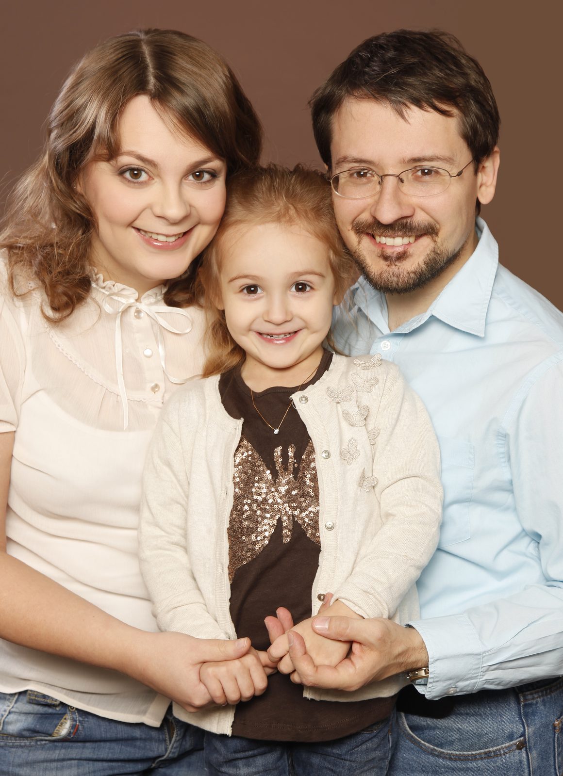Familie mit kleiner Tochter lächelt gemeinsam im Fotostudio in Hamburg
