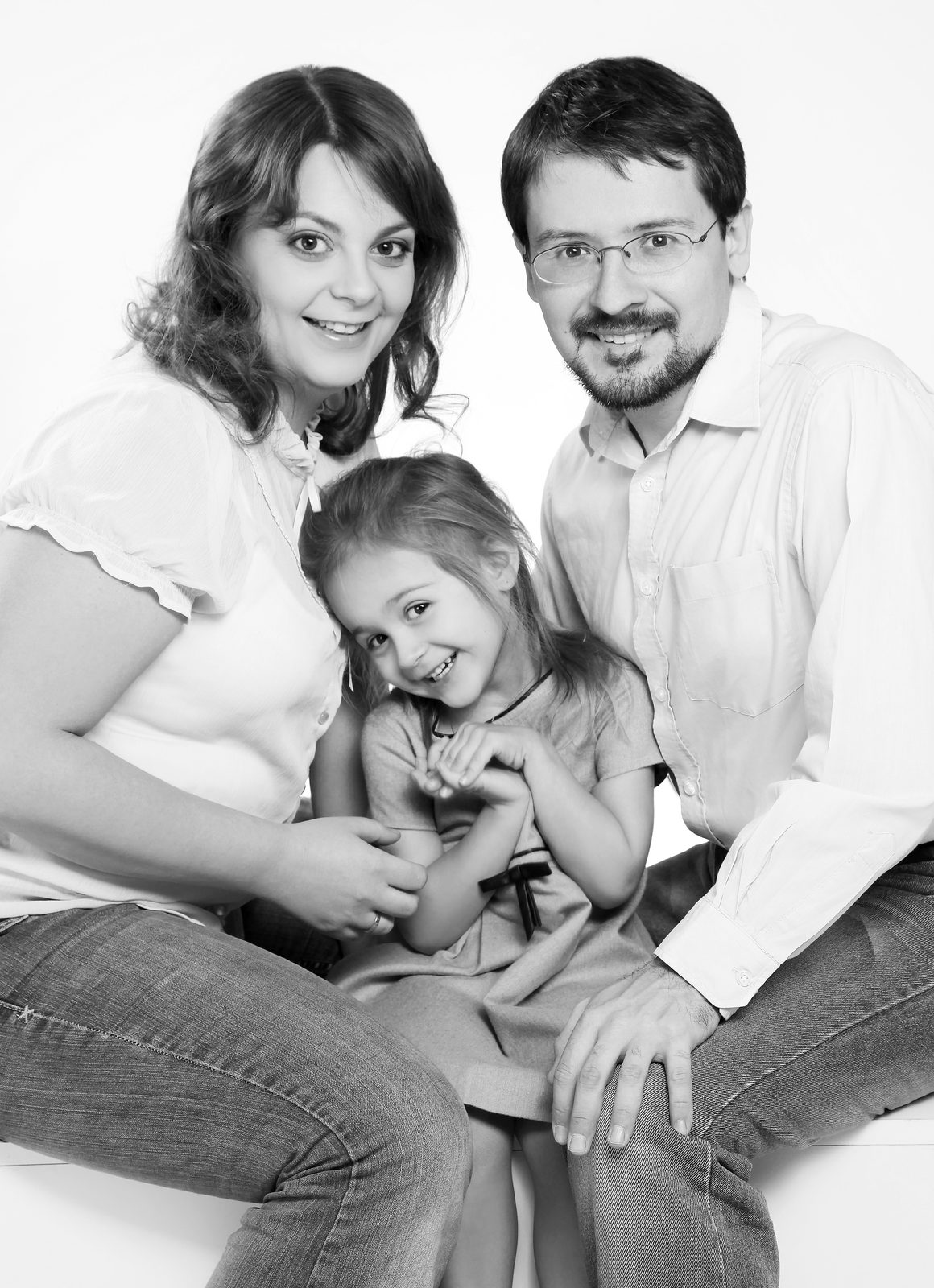 Familienporträt in Schwarz-Weiß – Mutter, Vater und Tochter lächeln im Fotostudio in Hamburg