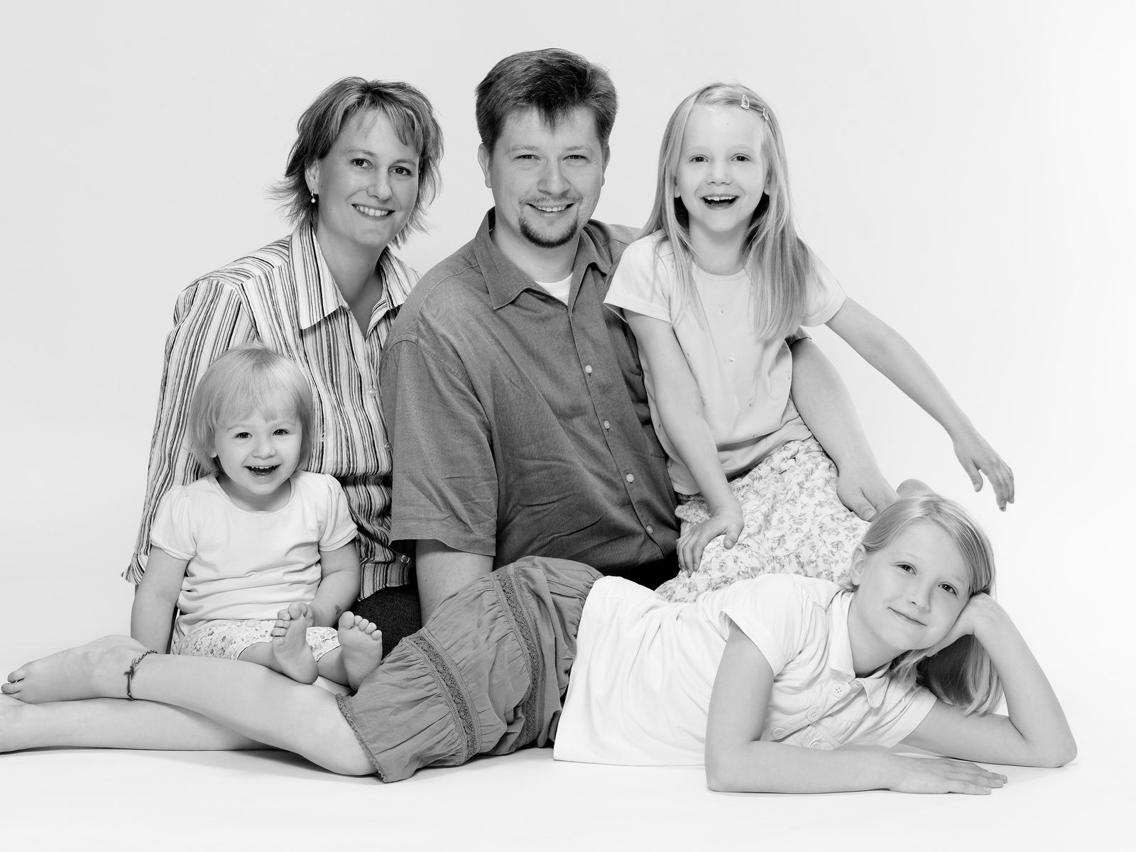 Familie mit drei Kindern lächelt gemeinsam bei einem Fotoshooting in Hamburg