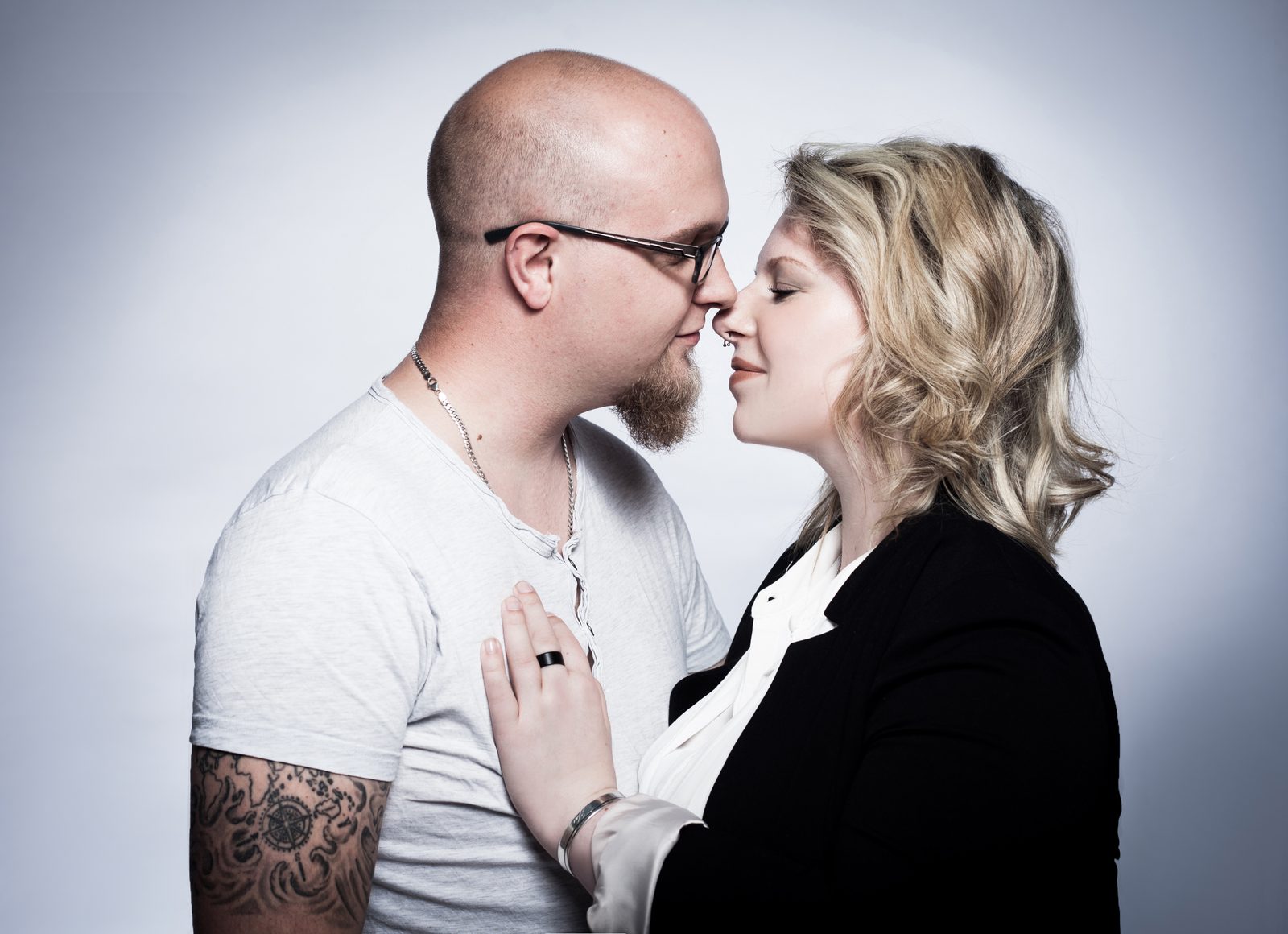 Paar steht Nase an Nase vor hellem Studiohintergrund
