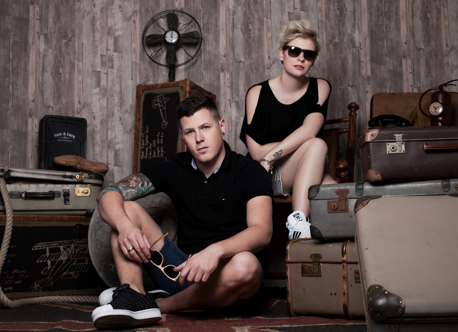 Paar sitzt lässig zwischen Vintage-Koffern im Fotostudio in Hamburg