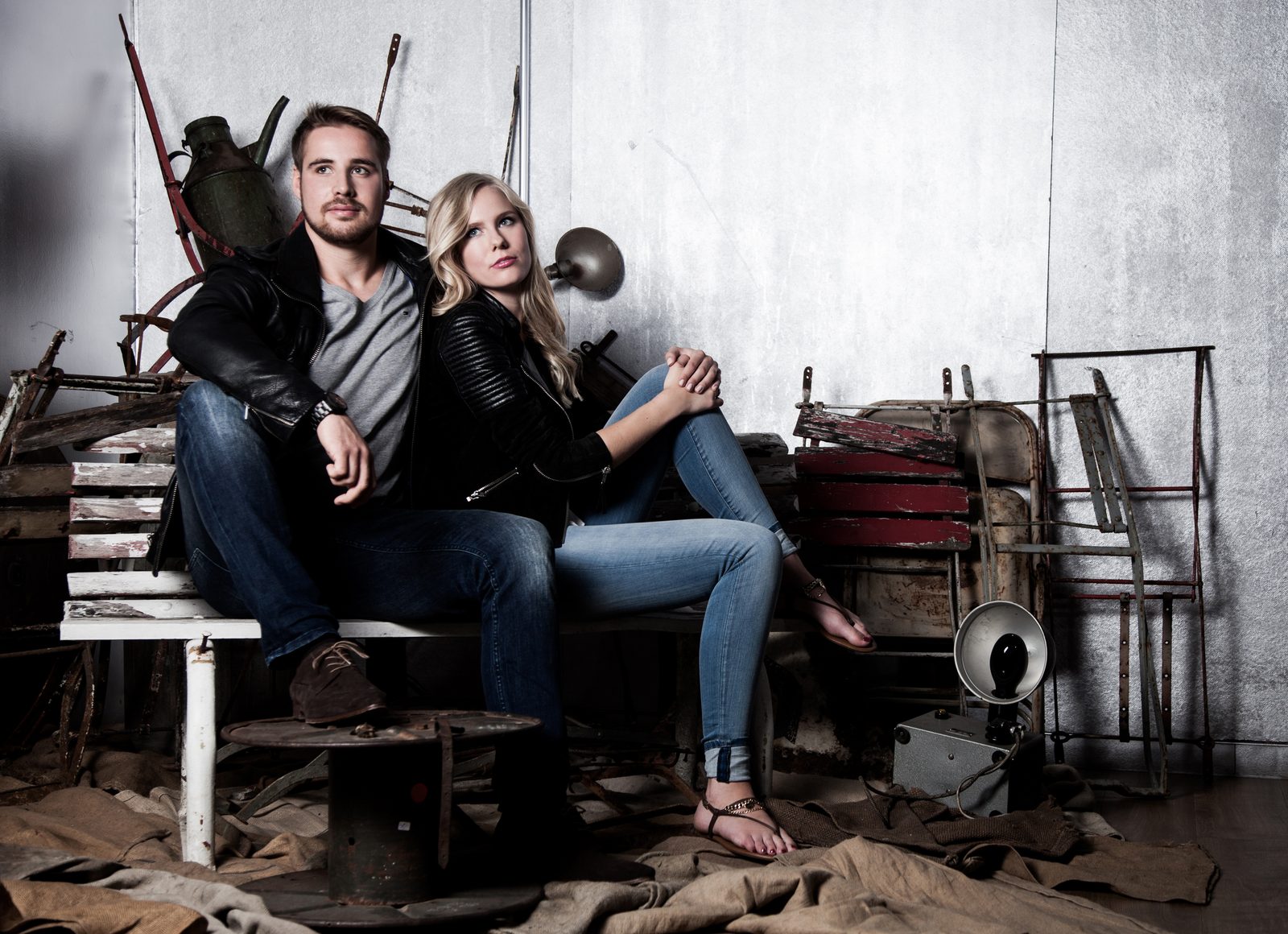 Couple in leather jackets sitting among vintage props in a Hamburg photo studio