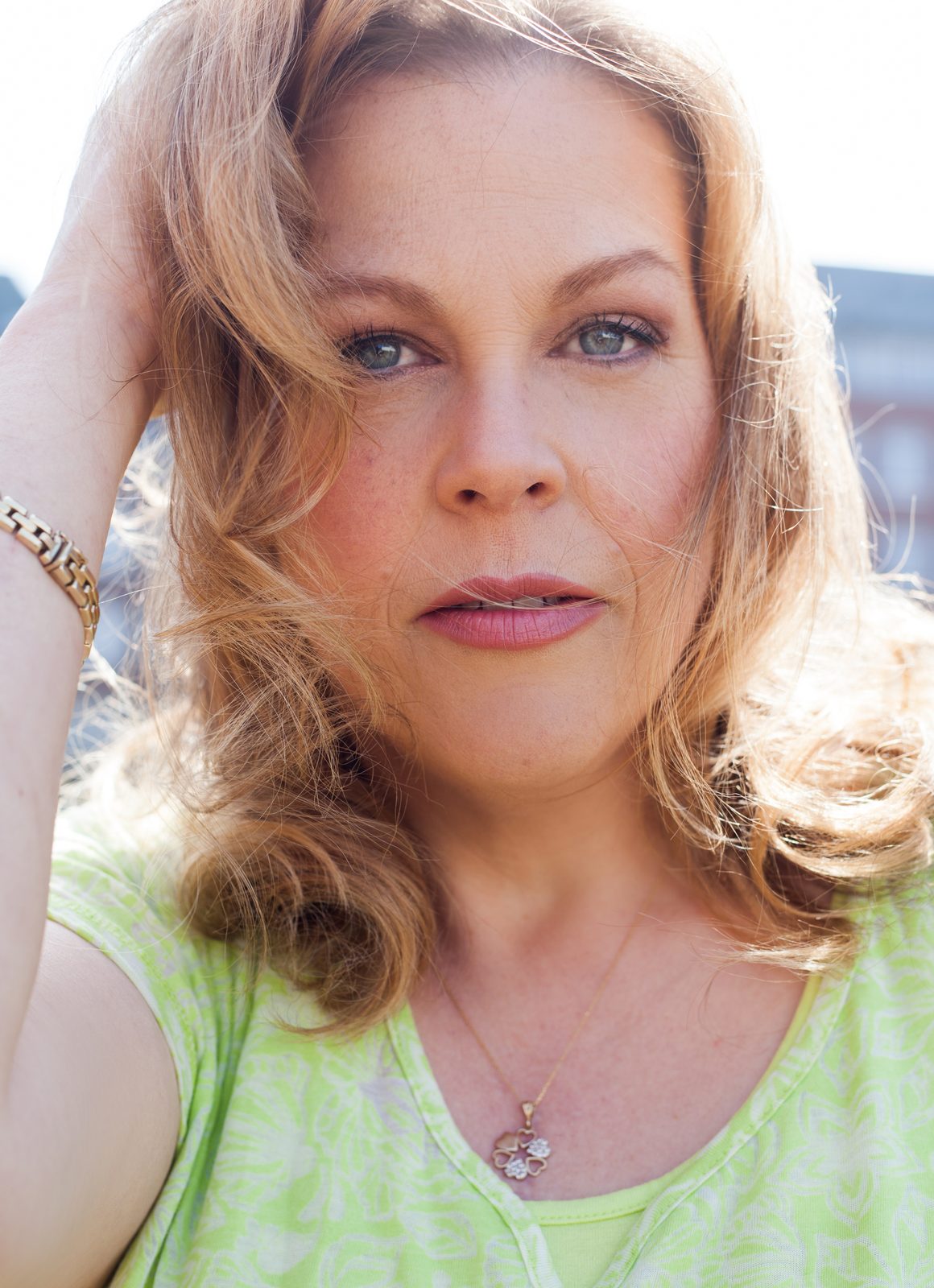 Porträt einer Frau mit blonden Locken im Freien – Fotoshooting in Hamburg