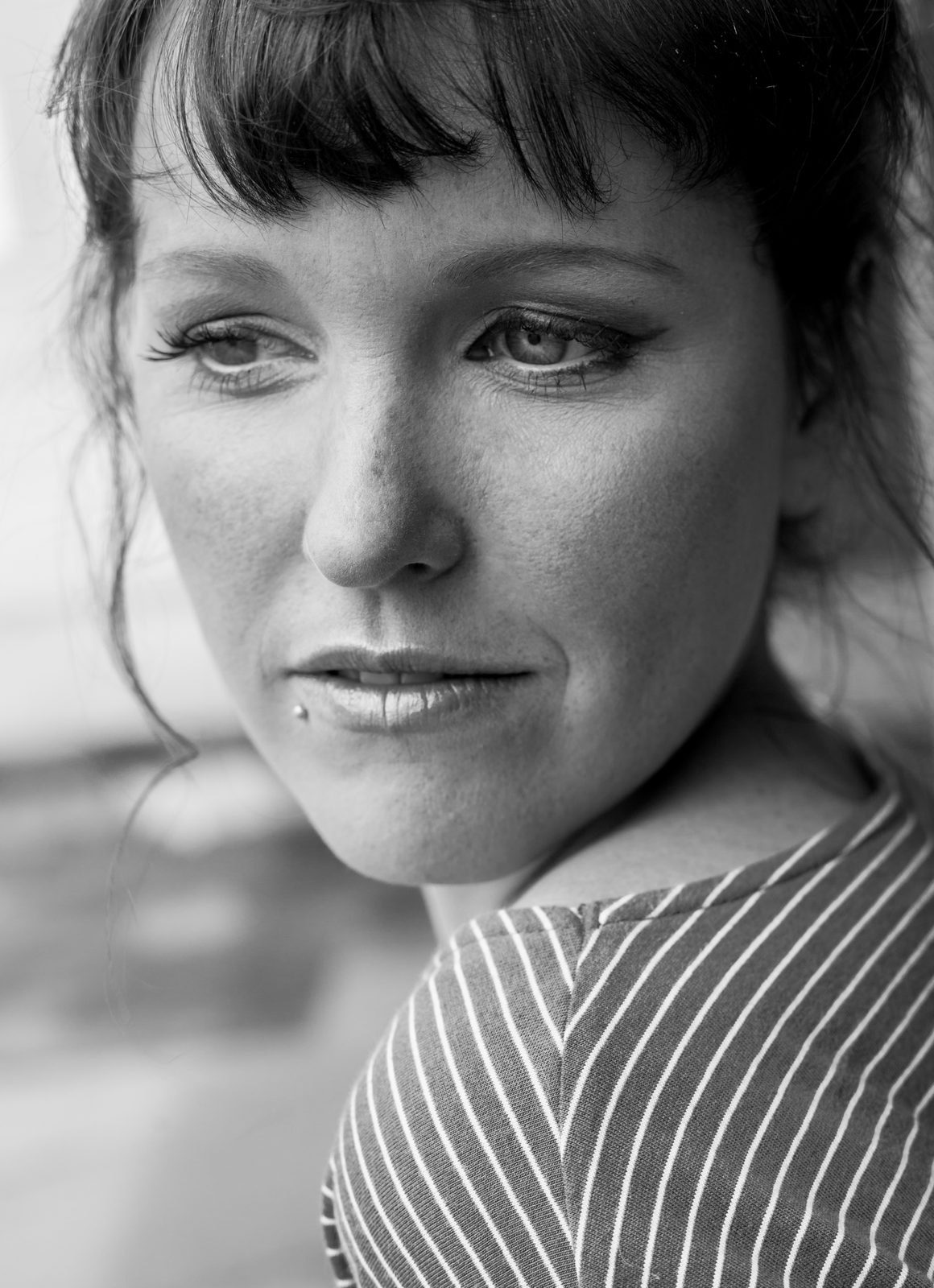 Black-and-white close-up portrait of a woman gazing thoughtfully to the side