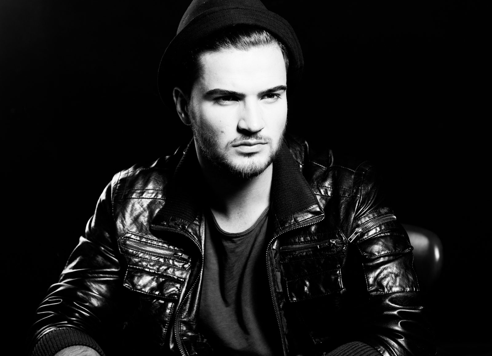 Schwarz-weiß-Porträt eines Mannes mit Beanie und Lederjacke im Fotostudio in Hamburg