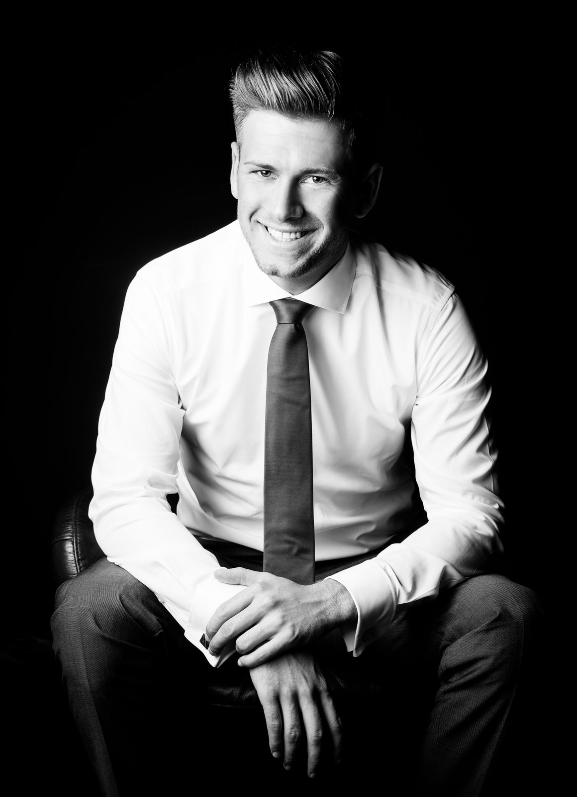 Lächelnder Mann in Hemd und Krawatte bei Fotoshooting in Hamburg, Schwarz-Weiß-Porträt