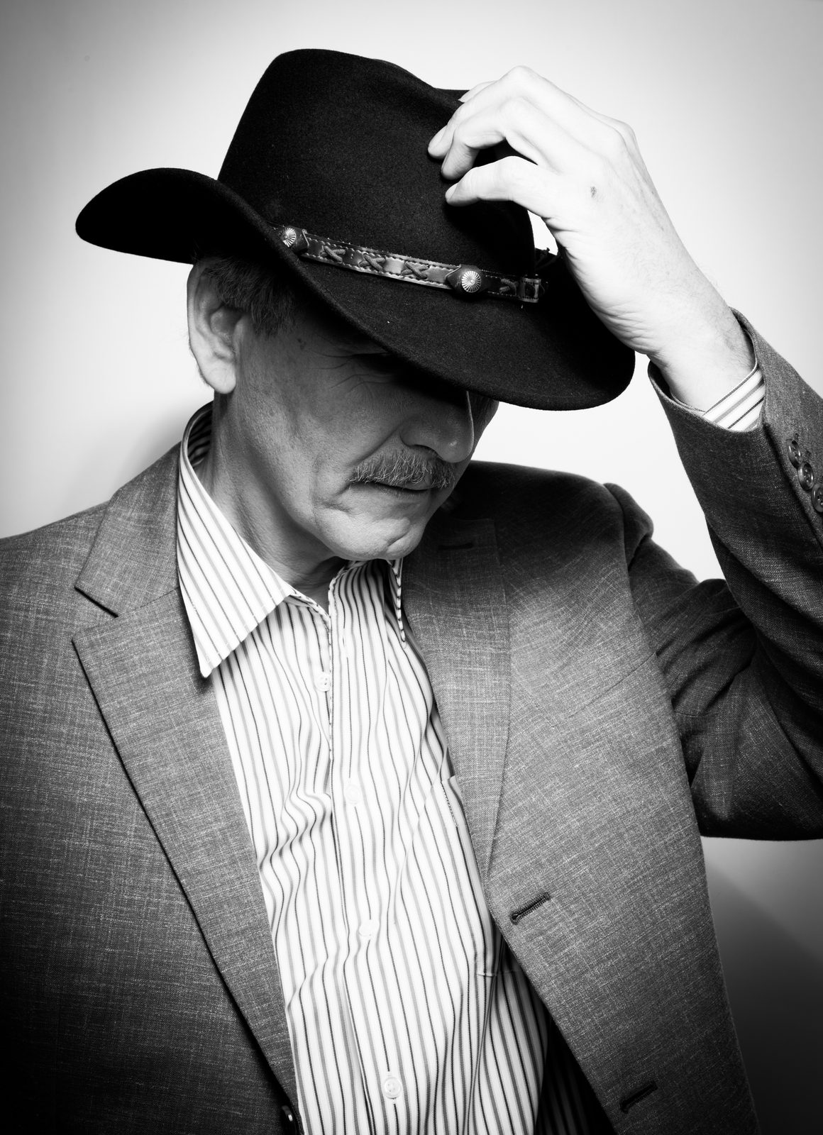 Mann mit Schnurrbart und Cowboyhut im Studio – Schwarz-Weiß-Porträt