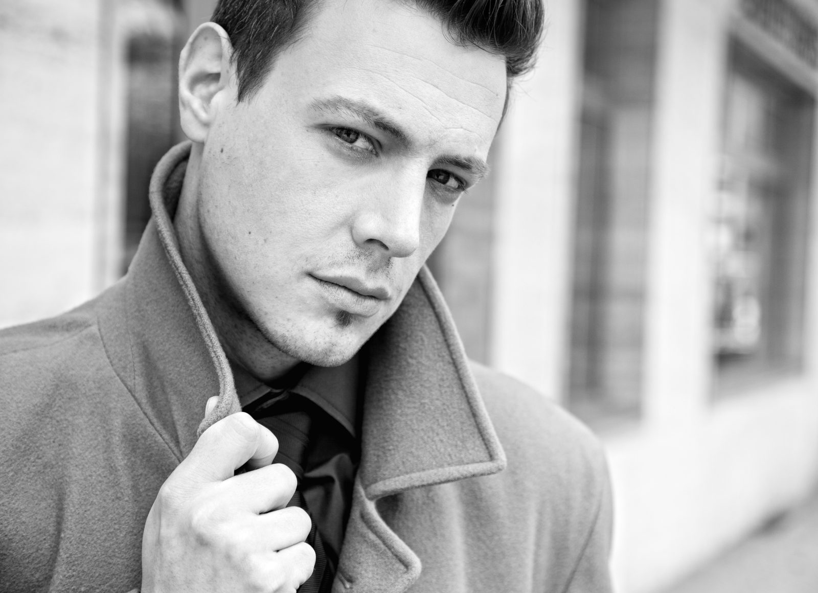Man in a coat with turned-up collar—black and white outdoor portrait